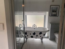 A bathroom with a bathtub, shower, and toilet at The Cow Shed in Bishopswood