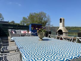 An outdoor seating area with a table and chairs at The Cow Shed in Bishopswood