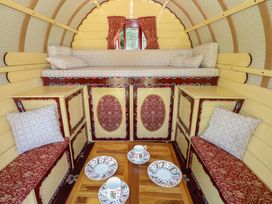 A living room with cushions and a table at The Bowtop Gypsy Caravan in Eye