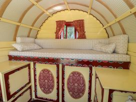 A sleeping area with a bed and cabinets at The Bowtop Gypsy Caravan in Eye