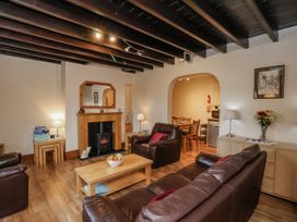 A living room with a fireplace and seating area at 2 High Stakesby Cottages in Whitby