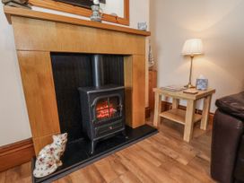 A living room with a fireplace and wood stove at 2 High Stakesby Cottages in Whitby