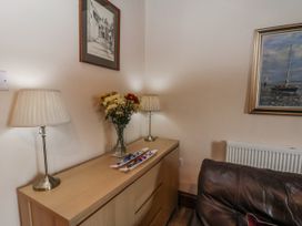 A living room with a chest of drawers and lamps at 2 High Stakesby Cottages Whitby