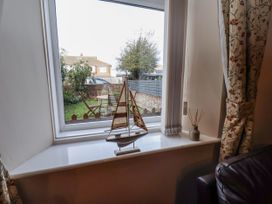 A living room with a window view of a garden at 2 High Stakesby Cottages in Whitby