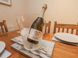 A champagne bottle in an ice bucket on a dining table at 2 High Stakesby Cottages Whitby