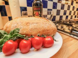 A kitchen scene with bread, tomatoes, basil, wine and glasses at 2 High Stakesby Cottages Whitby