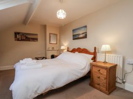 A bedroom with a bed and nightstand at 2 High Stakesby Cottages in Whitby