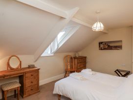 A bedroom with a bed and a dressing table at 2 High Stakesby Cottages in Whitby