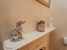 A mantel with a dog figurine, plant pot, and angel figurine at 2 High Stakesby Cottages, Whitby