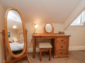 A bedroom with a dressing table and mirror at 2 High Stakesby Cottages Whitby