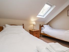 A bedroom with two beds and a lamp at 2 High Stakesby Cottages in Whitby