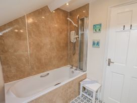 A bathroom with a bathtub and shower at 2 High Stakesby Cottages in Whitby