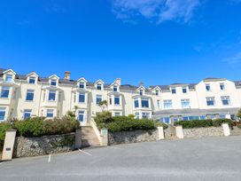 A building with windows and a parking lot at 19 Cliff Apartments in Trearddur Bay