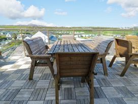 An outdoor patio with wooden furniture at 19 Cliff Apartments in Trearddur Bay