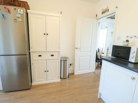 A kitchen with a refrigerator and cupboard at 19 Cliff Apartments in Trearddur Bay