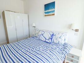 A bedroom with a bed and wardrobe at 19 Cliff Apartments in Trearddur Bay