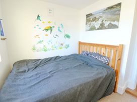 A bedroom with a bed and wall art at 19 Cliff Apartments in Trearddur Bay