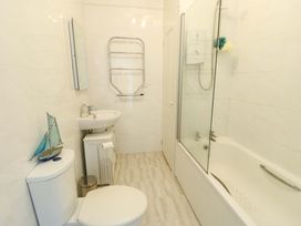A bathroom with a sink, toilet, bathtub, and shower at 19 Cliff Apartments in Trearddur Bay