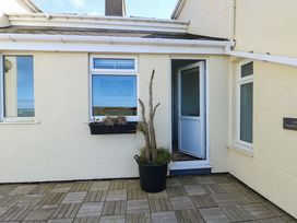 An entrance area with a door and plant at 19 Cliff Apartments in Trearddur Bay