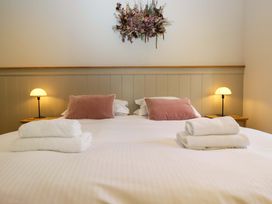 A bedroom with a bed, pillows, and towels at The Old Bunkhouse in Grasmere