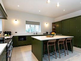 A kitchen with green cabinets and an island at The Old Bunkhouse in Grasmere