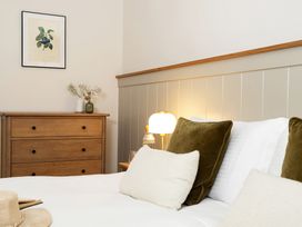 A bedroom with a bed, lamp, and chest of drawers at The Old Bunkhouse in Grasmere