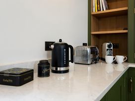 A kitchen with a kettle, toaster, coffee machine and cups at The Old Bunkhouse in Grasmere