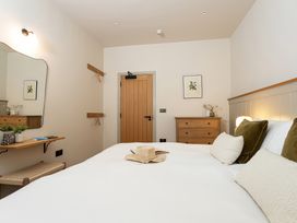 A bedroom with a bed and a mirror at The Old Bunkhouse in Grasmere