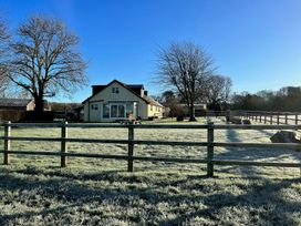 A house with trees and a fence in a field at Court House Farmhouse Charmouth