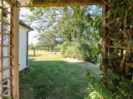 A garden view with grass and trees at Court House Farmhouse in Charmouth