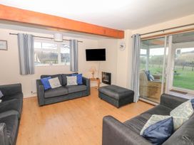 A living room with sofas and a television at Court House Farmhouse in Charmouth