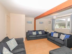 A living room with sofas and a lamp at Court House Farmhouse in Charmouth