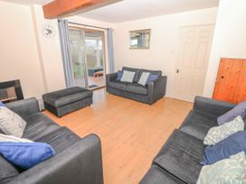 A living room with sofas and an ottoman at Court House Farmhouse in Charmouth