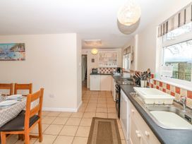 A kitchen with a dining table and appliances at Court House Farmhouse in Charmouth