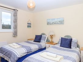 A bedroom with two beds and a window at Court House Farmhouse in Charmouth