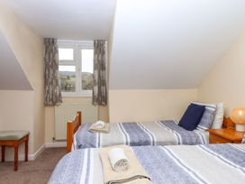 A bedroom with two beds and a window at Court House Farmhouse Charmouth