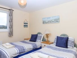 A bedroom with two single beds and a window at Court House Farmhouse in Charmouth