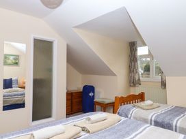 A bedroom with two beds and a dresser at Court House Farmhouse in Charmouth