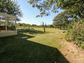 A garden with a table and trees at Court House Farmhouse in Charmouth