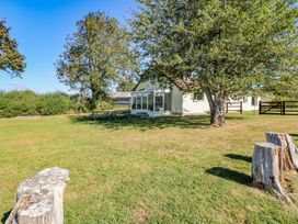 An outdoor view of a house with a table and trees at Court House Farmhouse in Charmouth