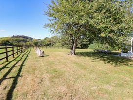 A garden with a tree and benches at Court House Farmhouse in Charmouth