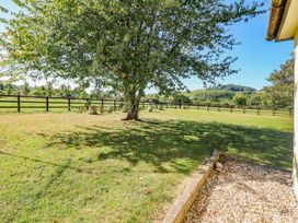 A garden with a tree and stools at Court House Farmhouse in Charmouth