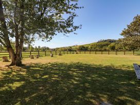 An outdoor garden with a tree and seating at Court House Farmhouse Charmouth