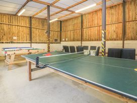 A game room with a table tennis table and chairs at Court House Farmhouse in Charmouth