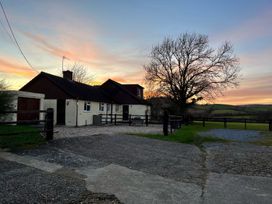 A house with a tree and fence at Court House Farmhouse in Charmouth