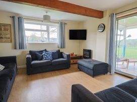 A living room with sofas and a television at Court House Farmhouse in Charmouth
