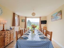 A dining room with a large table set for a meal at Court House Farmhouse in Charmouth