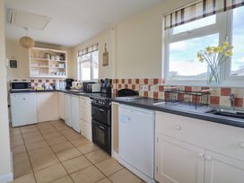 A kitchen with a stove and refrigerator at Court House Farmhouse in Charmouth