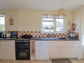 A kitchen with a sink, oven, and dishwasher at Court House Farmhouse in Charmouth