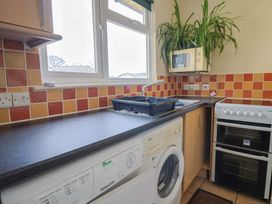 A kitchen with sink, washing machine, microwave and oven at Court House Farmhouse in Charmouth